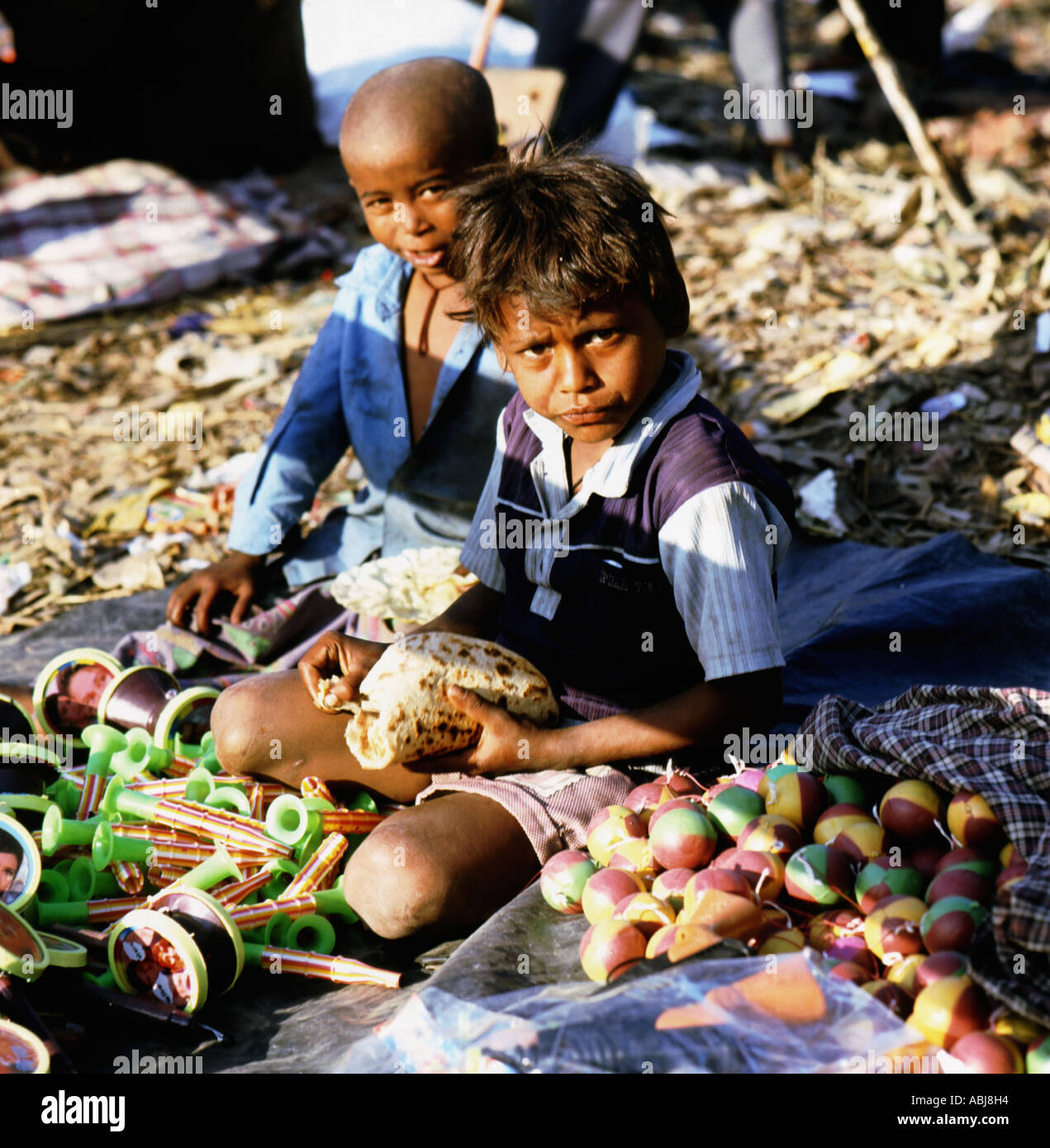 Two Indian boys eating roti bread Stock Photo - Alamy