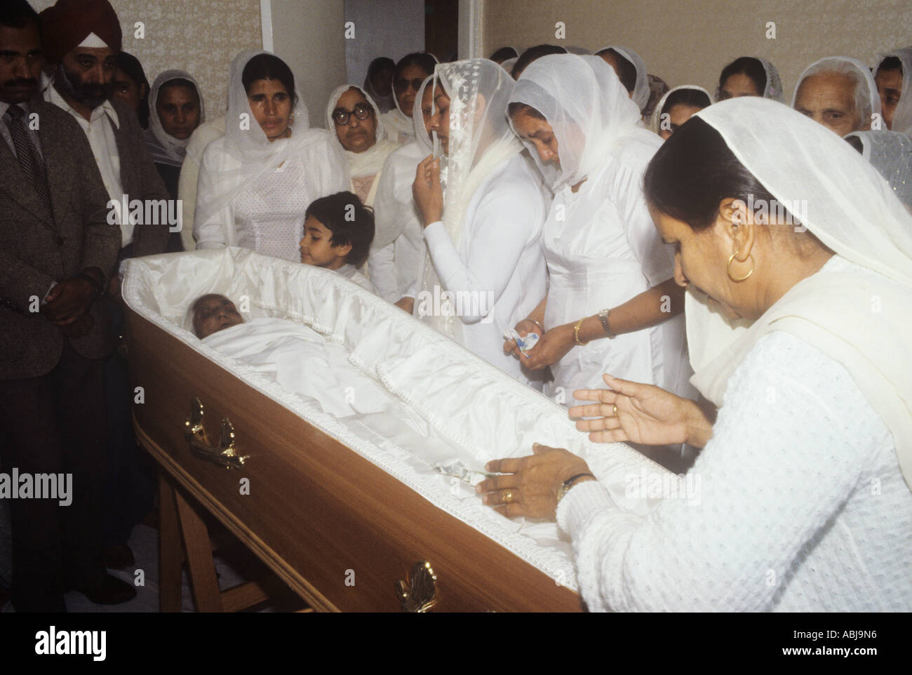 Members of a Sikh family view a deceased before the funeral, England