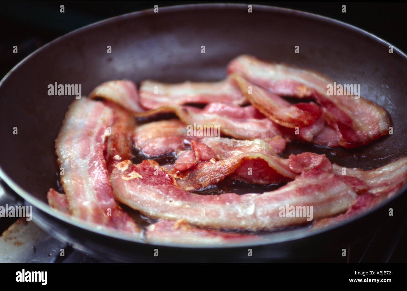 streaky bacon frying in pan Stock Photo Alamy