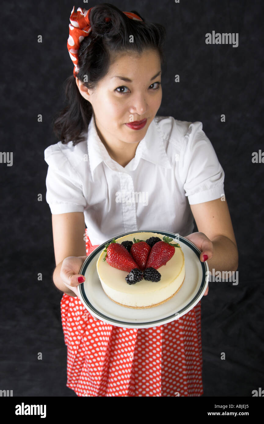 Marianne Cheesecake Chinese Girl Holding a Cheesecake Decorated with Strawberries and Blackberries on a Plate Stock Photo