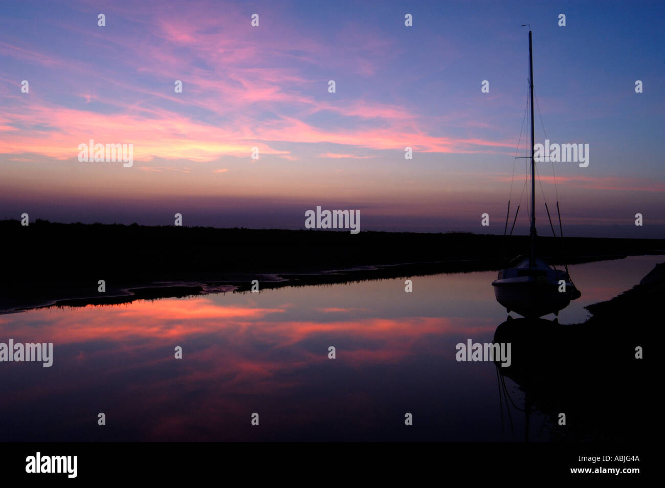 stunning purple and deep pink sunset at blakeney norfolk england in september Stock Photo