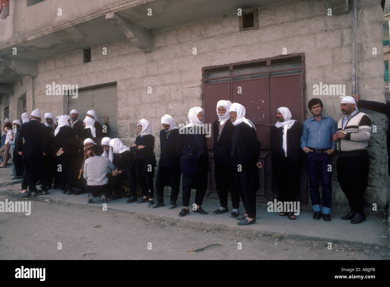 Syrian Druze community people in the Golan Heights Israel One young man in western style clothing amongst many men in traditional clothing 1980s 1982 Stock Photo