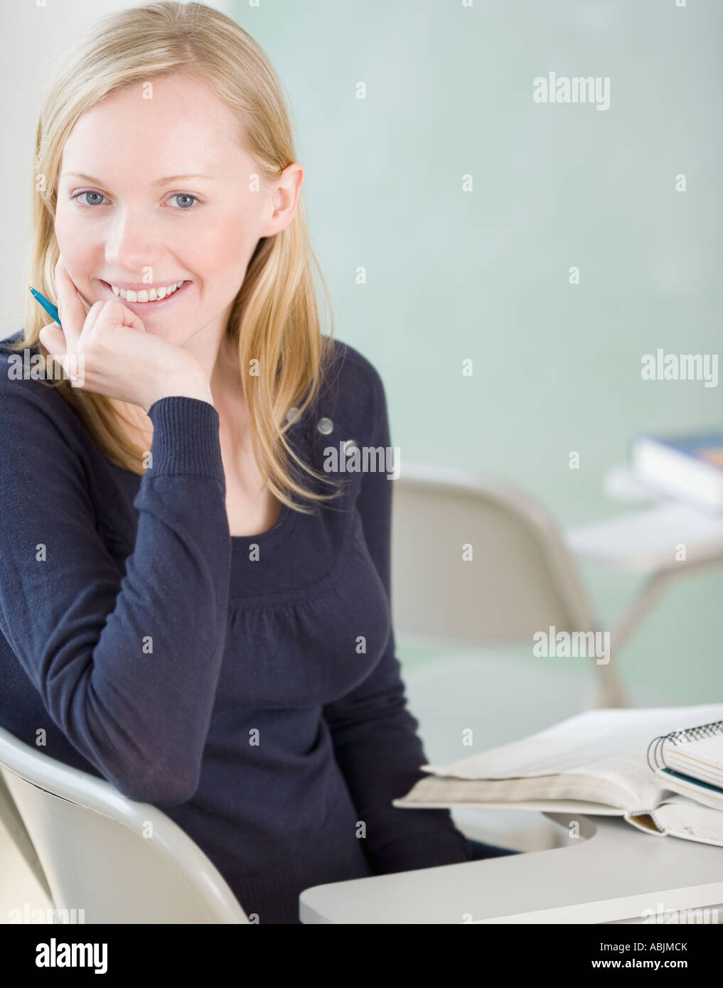Woman sitting at desk in classroom Stock Photo - Alamy