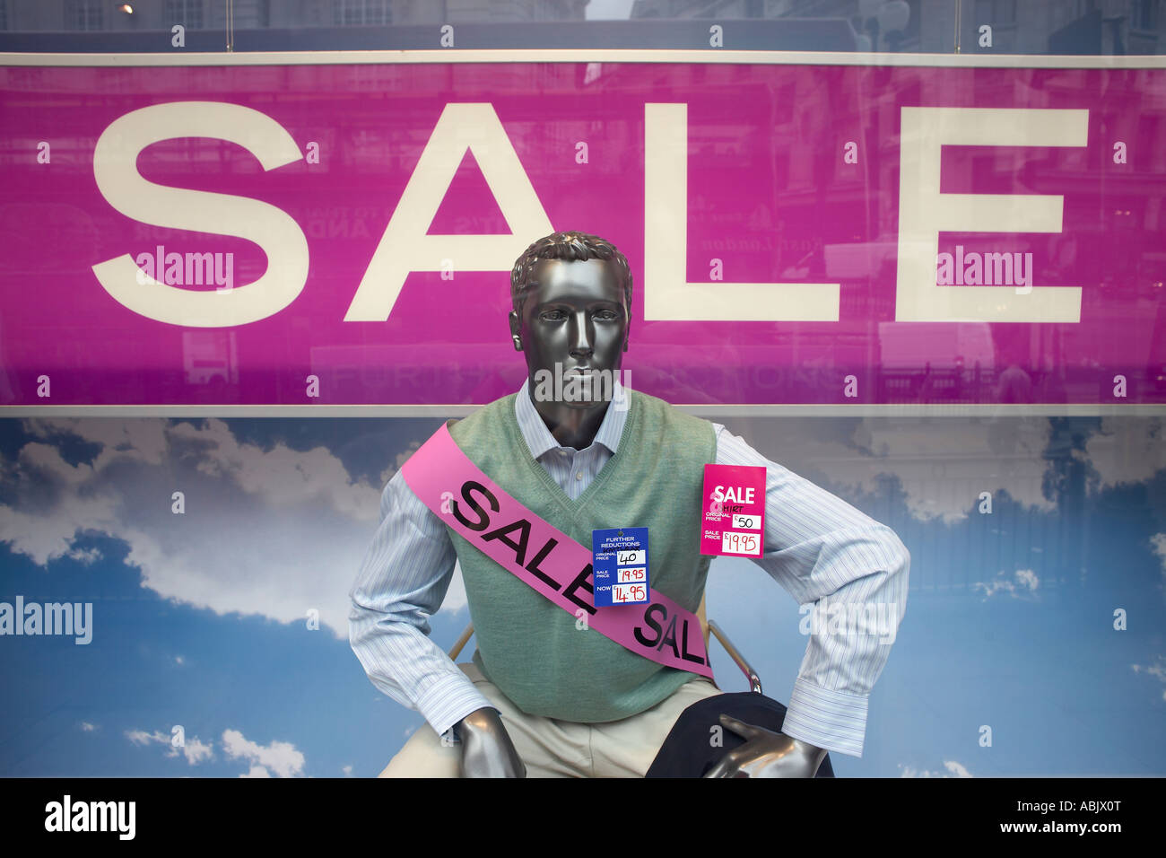 A shop window Sale mannequin, wearing a sash, is in the wide window pane of Austin Reed outfitters, Regent Street London. Stock Photo