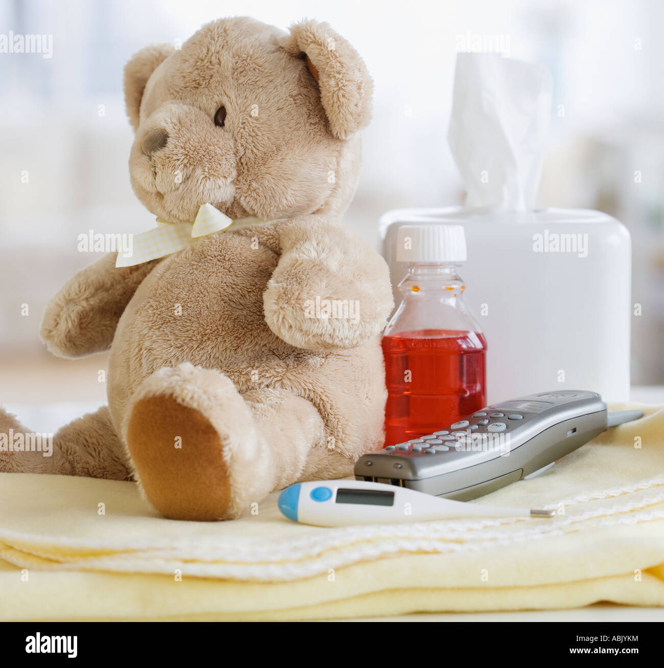 Teddy bear medication thermometer and telephone on blanket Stock Photo -  Alamy