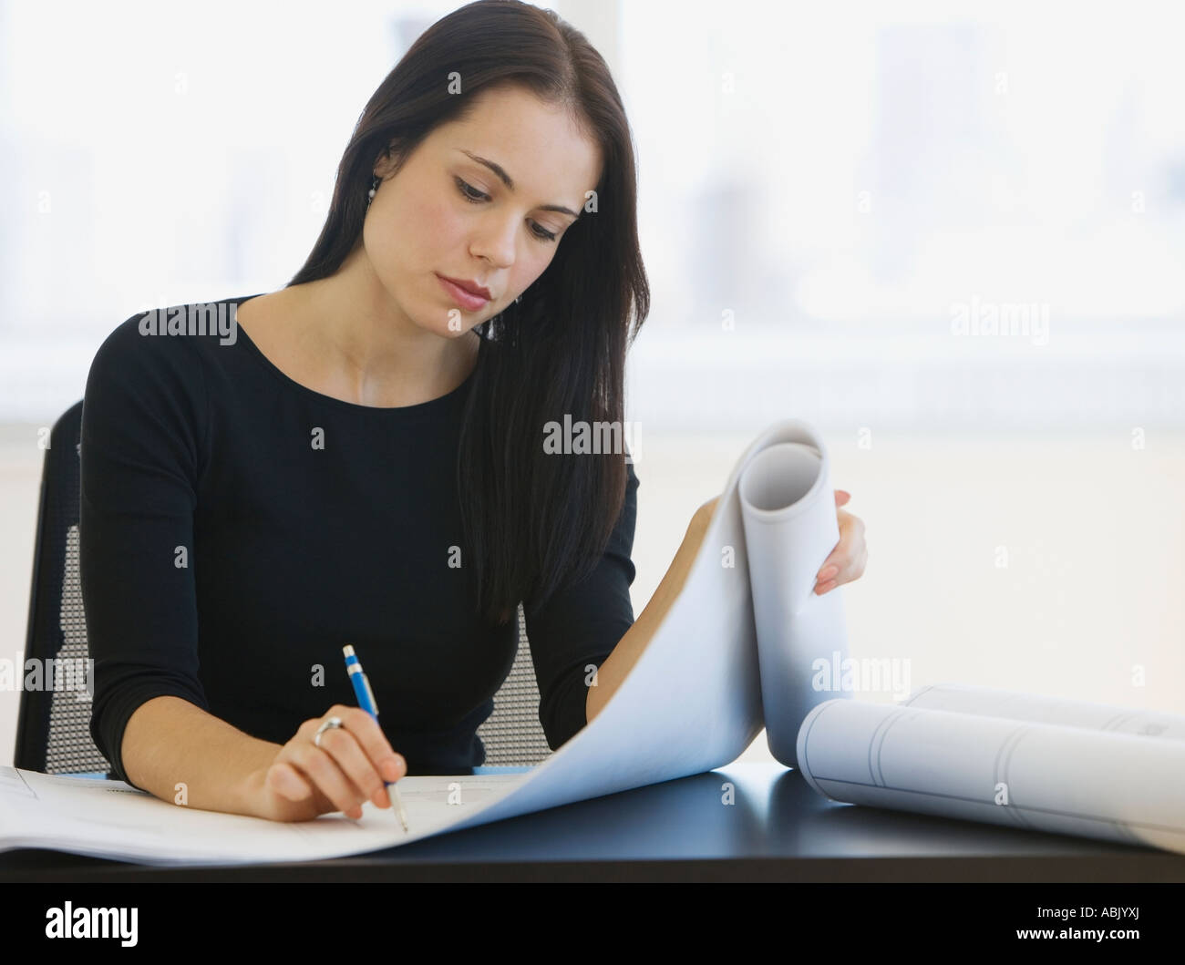 Female architect writing on blueprints Stock Photo Alamy