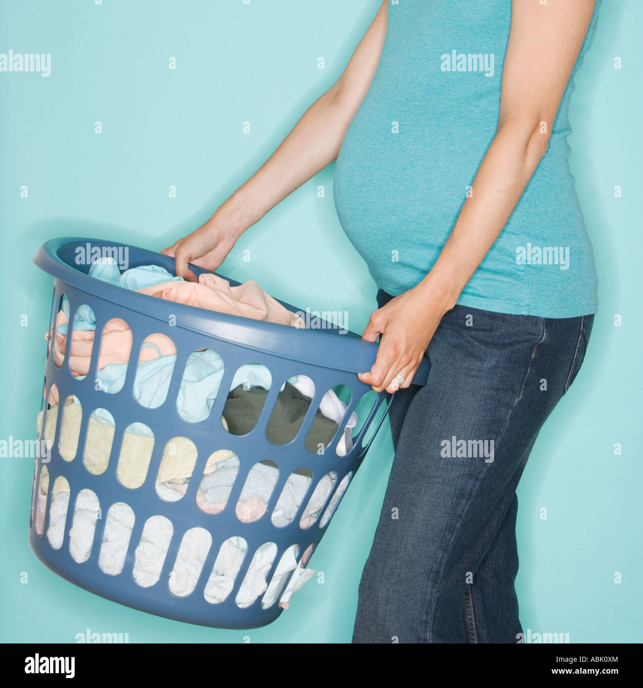 Pregnant woman carrying laundry basket Stock Photo Alamy