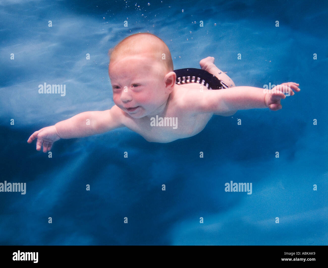 baby swimming underwater blue background Stock Photo Alamy