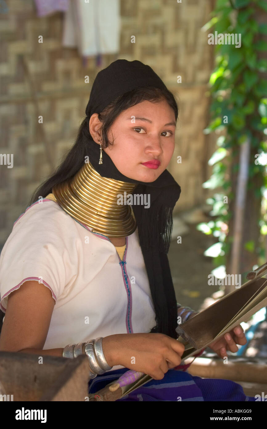 Kareni woman weaving cloth at loom with brass coils around her neck long neck village thailand