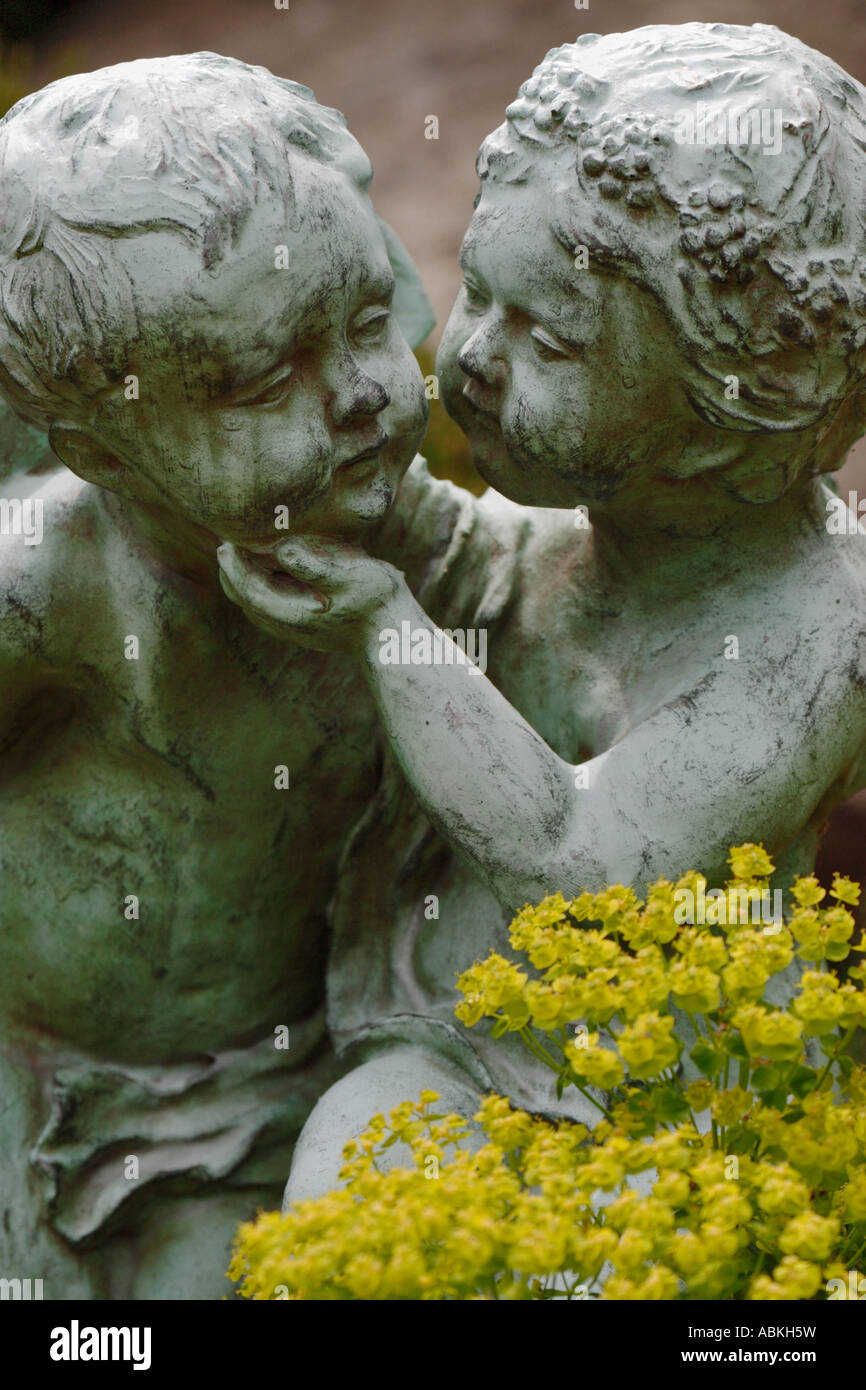 Portrait of garden sculpture of young lovers with yellow flowers in foreground Stock Photo