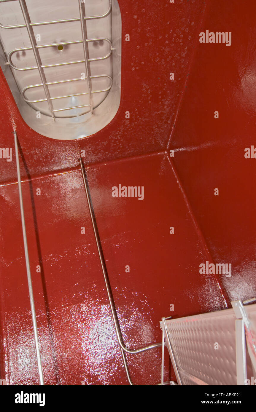 Inside a concrete fermentation tank: painted red and a cooling / heating curtain heat exchanger for temperature control and the Stock Photo