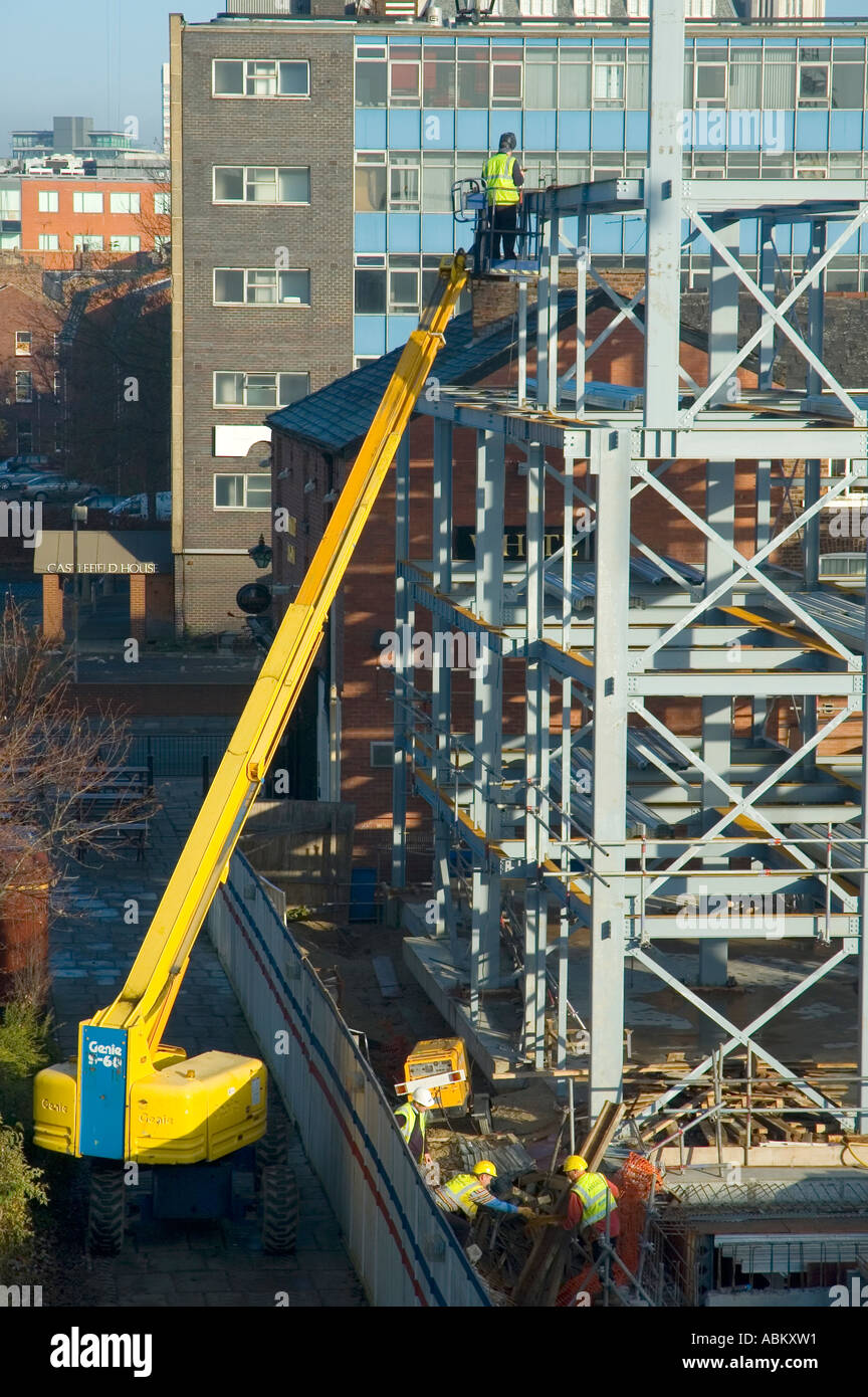 Welder working from a mobile access platform on a construction site in Manchester, England, UK Stock Photo