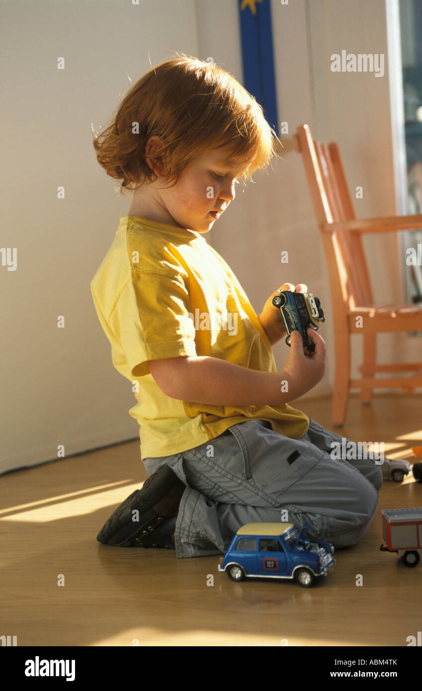 Little boy is playing on the floor with toy cars Stock Photo - Alamy