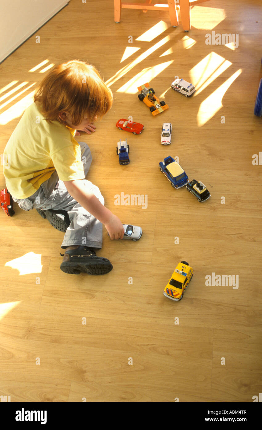 Little boy is playing on the floor with toy cars Stock Photo - Alamy