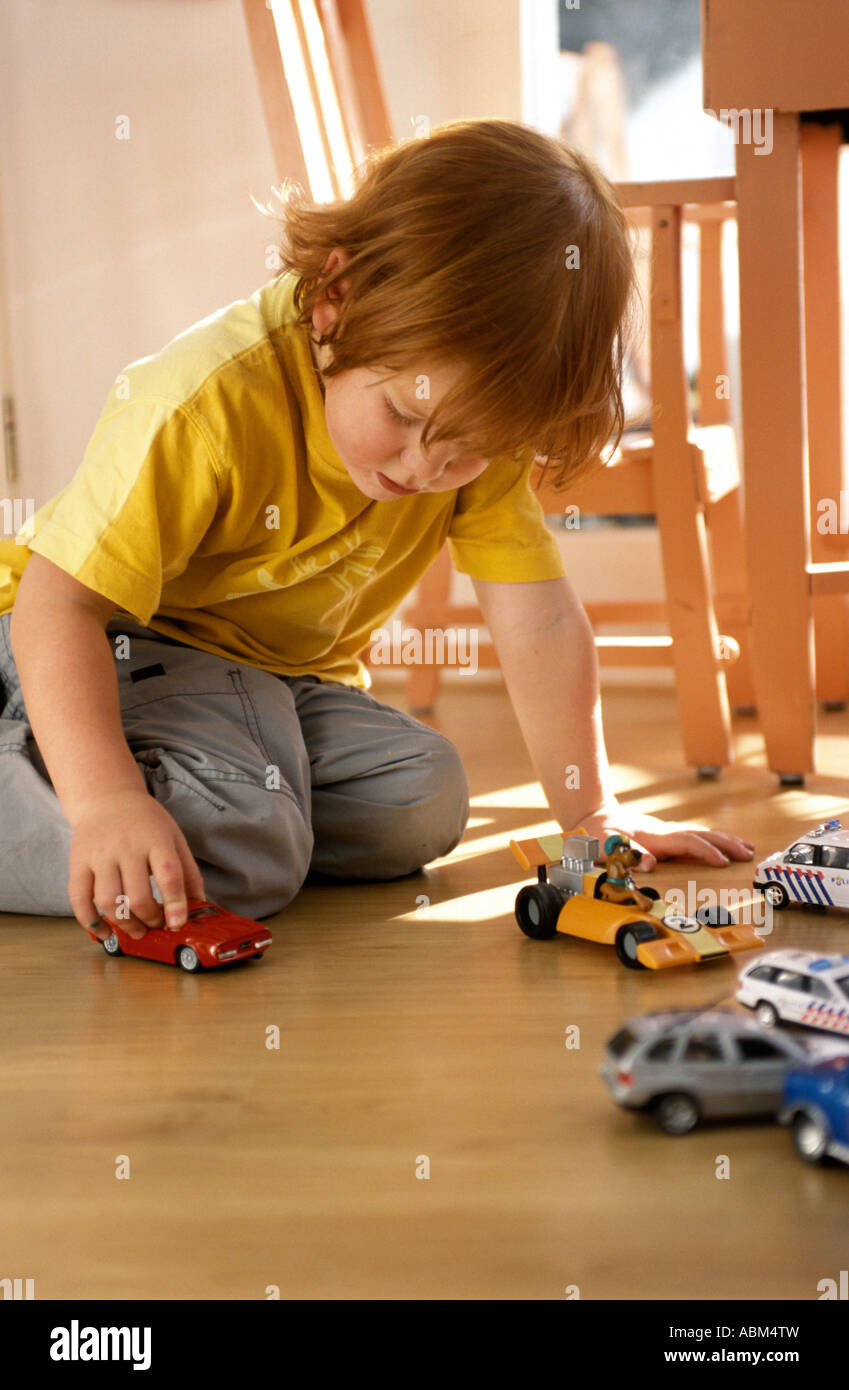 Little boy is playing on the floor with toy cars Stock Photo - Alamy