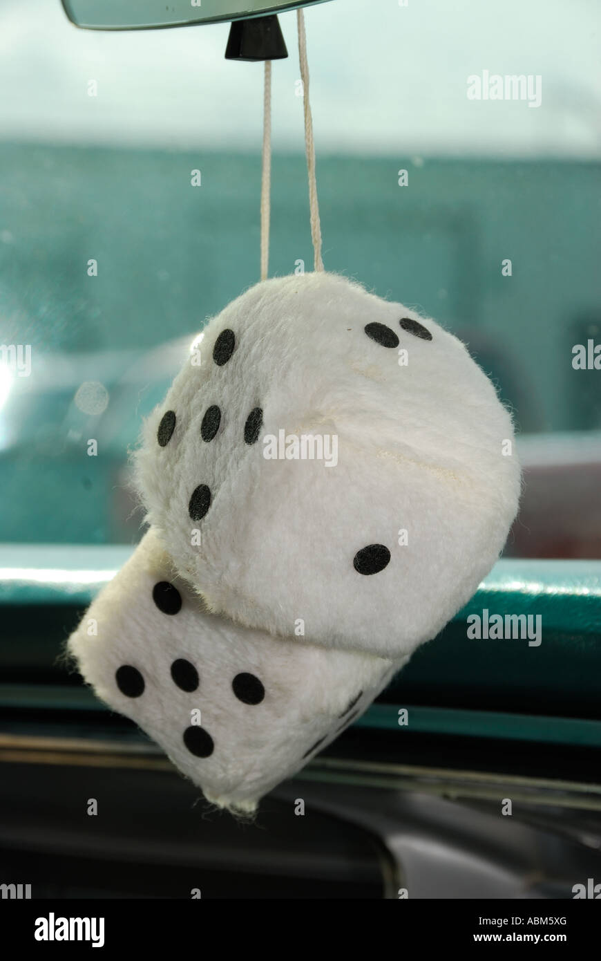 Fuzzy Dice Hanging From A Car's Rear View Mirror by Stocksy