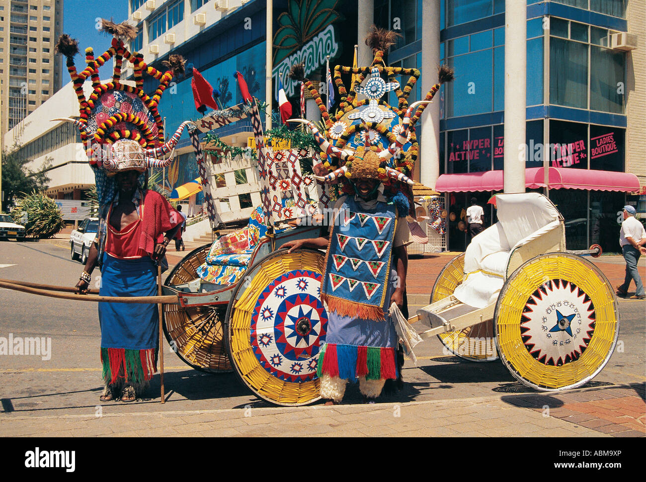 Rickshaw men with colourful constumes Durban beach front Natal South ...