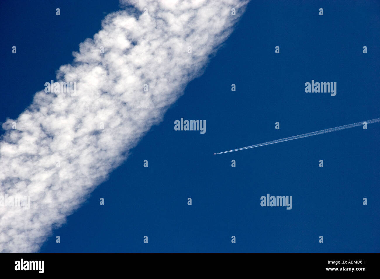 Vapor contrails from high flying jet aircraft The larger has been blown apart by the wind Stock Photo