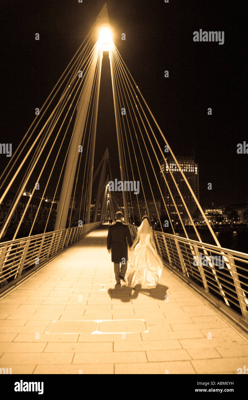 Bride and groom take a walk over a london bridge after their wedding at St Pauls Church in London Stock Photo