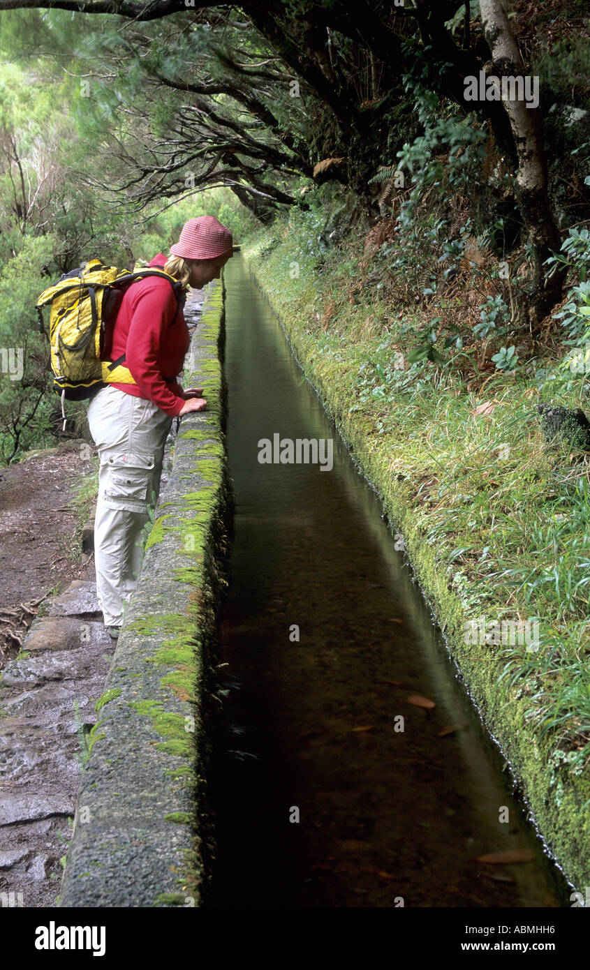 Woman at levada irrigation canal and footpath, Madeira Stock Photo