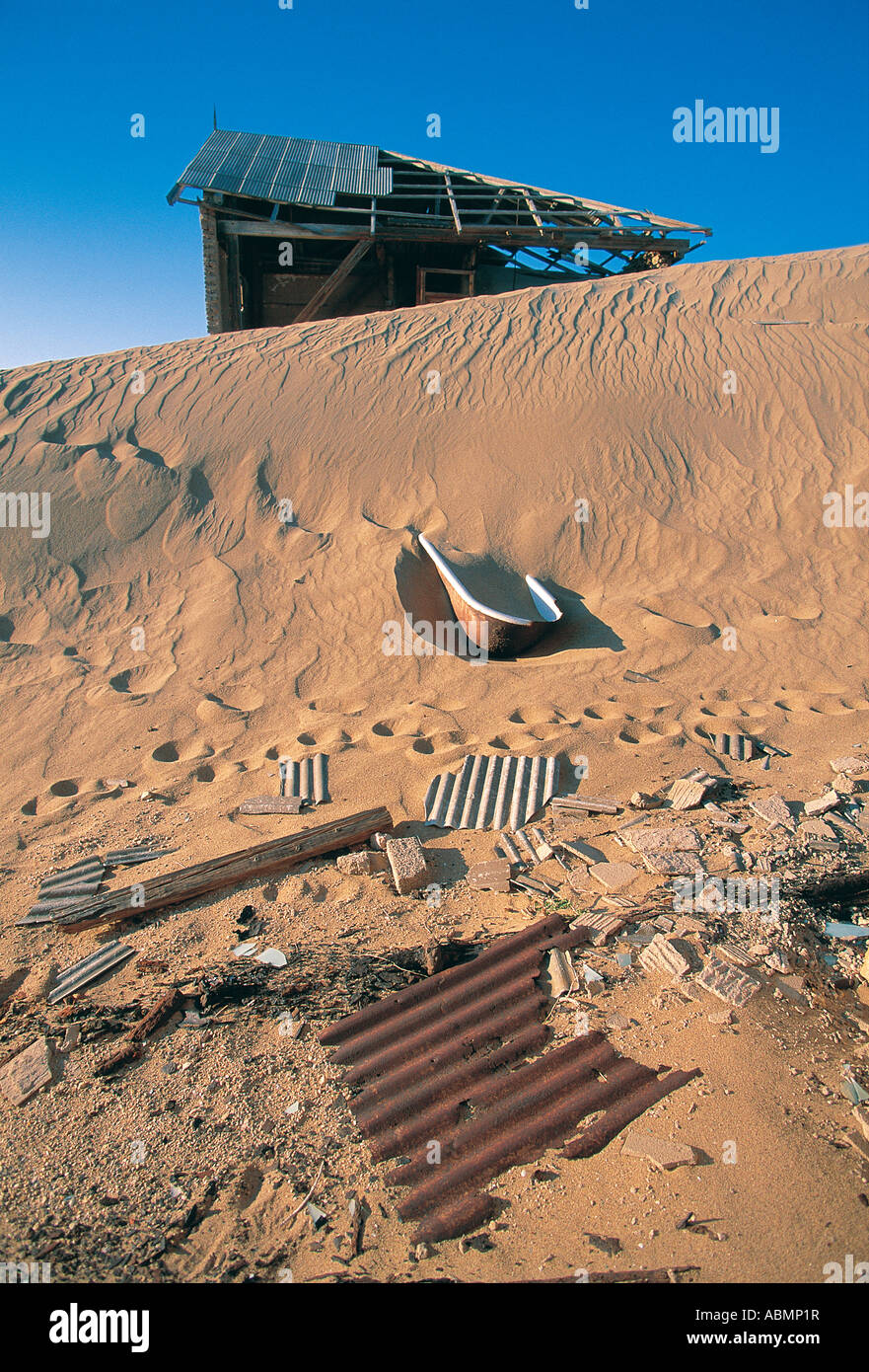 The wreckage of an abandoned house engulfed by sand dunes in the Ghost town of Kolmanskop near Luderitz Namibia Stock Photo
