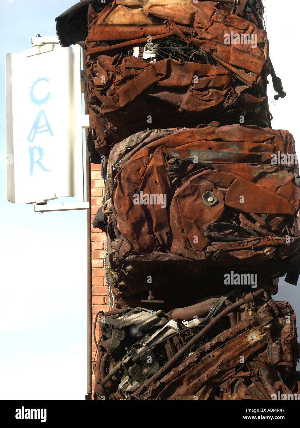 stacked crushed cars used as the wall to a car yard in birmingham