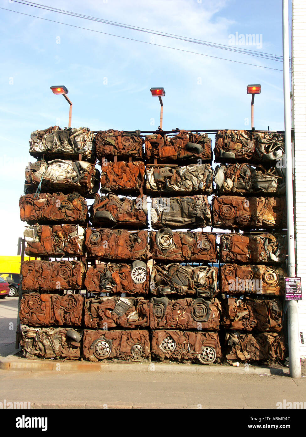 stacked crushed cars used as the wall to a car yard in birmingham