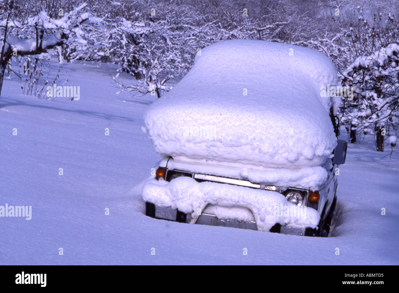 Blizzard conditions leave car covered in snow Stock Photo