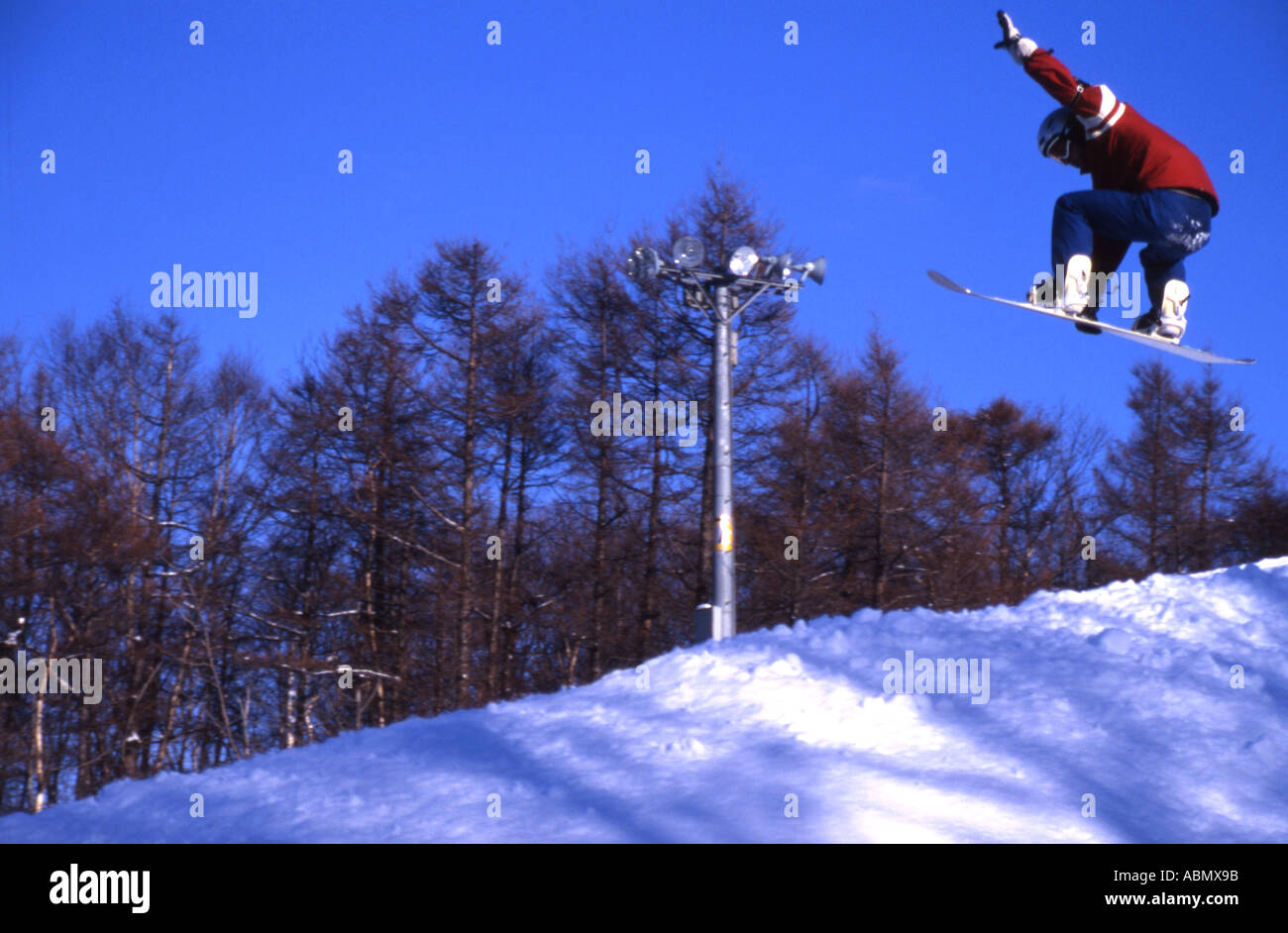Snowboarder flies through the air in Hokkaido Japan Stock Photo