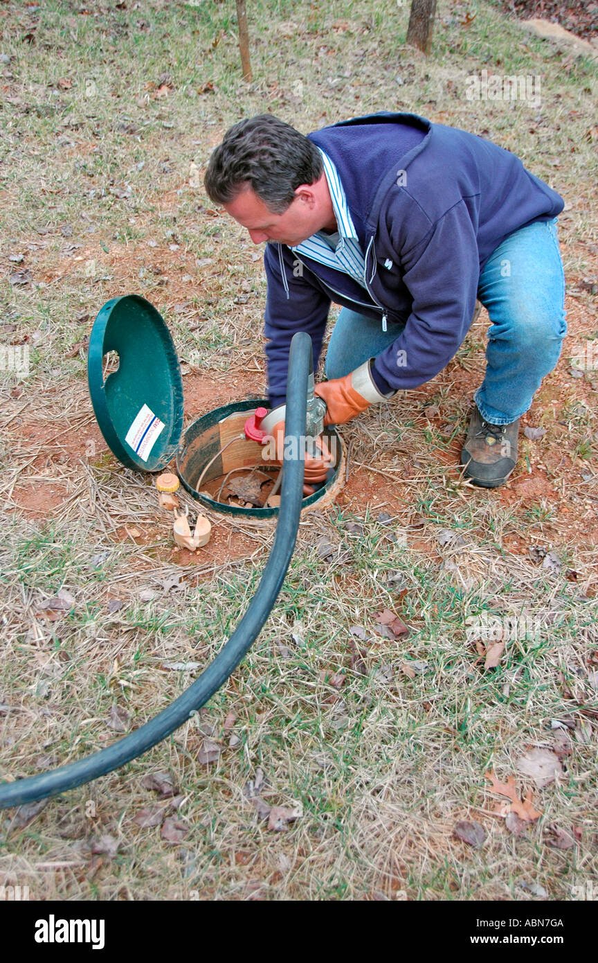Propane delivery man putting pumping natural gas into underground tank