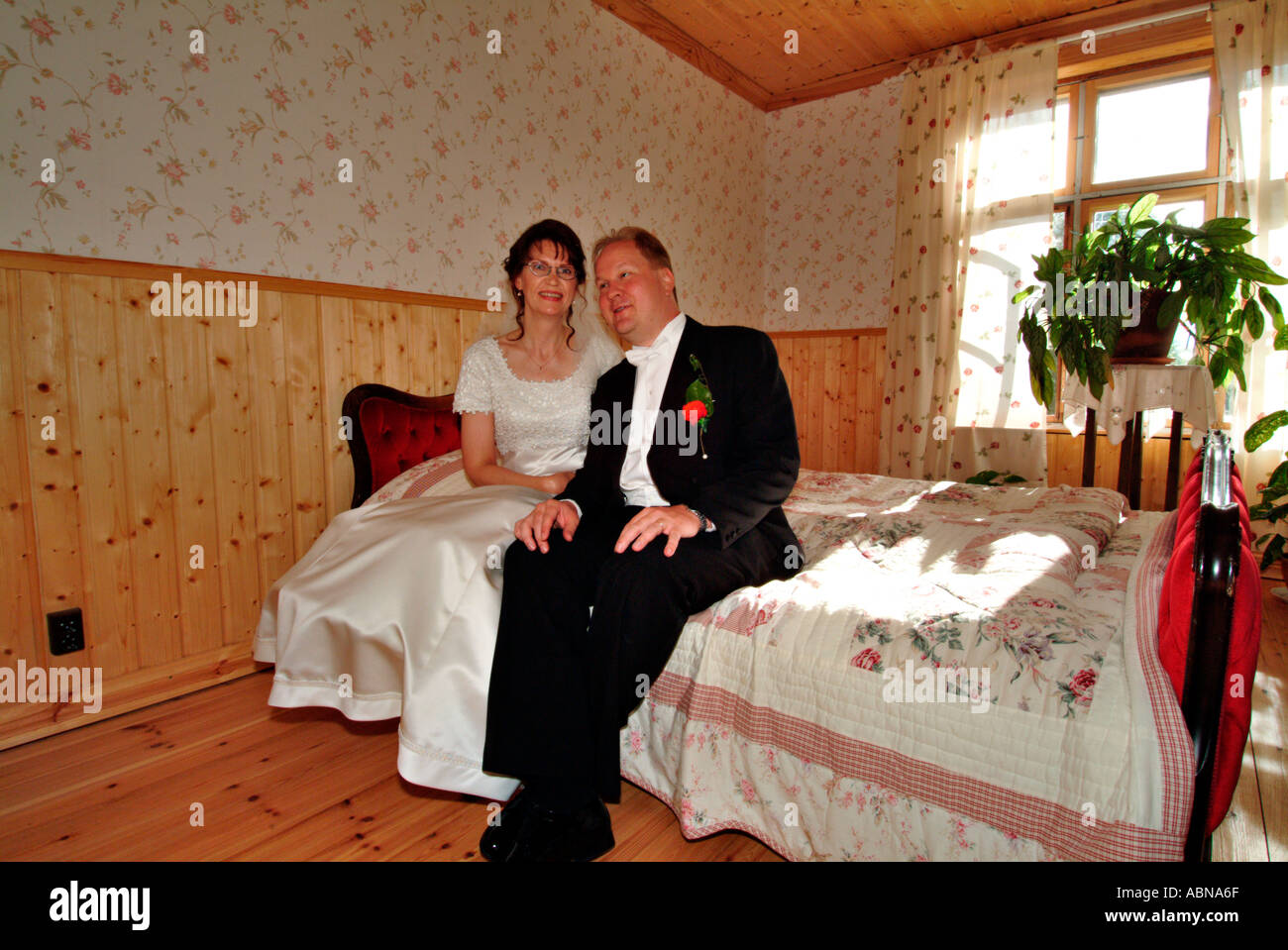 bridal pair sitting on a double bed MR Stock Photo