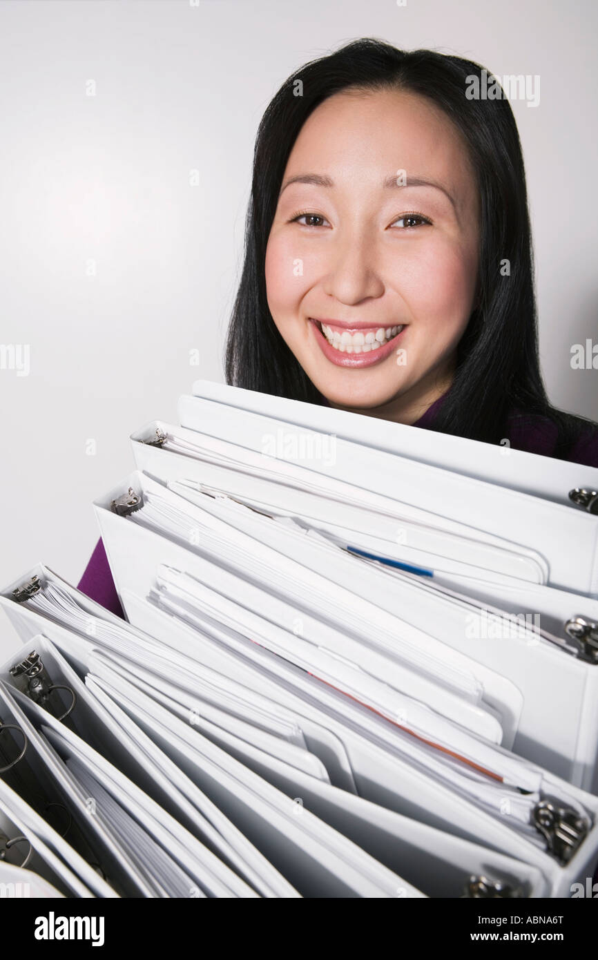 Businesswoman carrying stack of binders Stock Photo Alamy