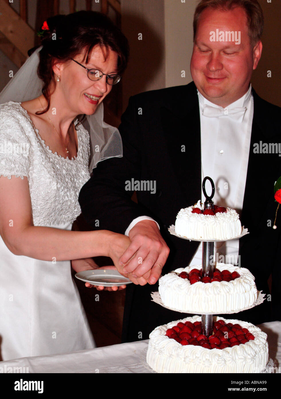 bridal pair cutting together the wedding cake MR Stock Photo