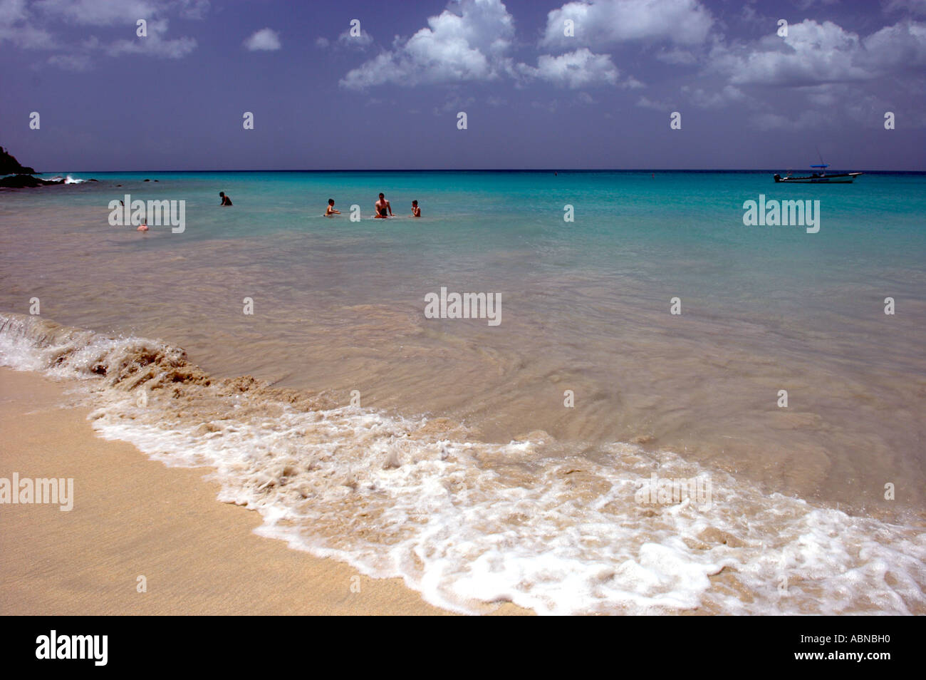 Beach with people playing out beyond the light surf Grand Anse Beach Grenada Stock Photo