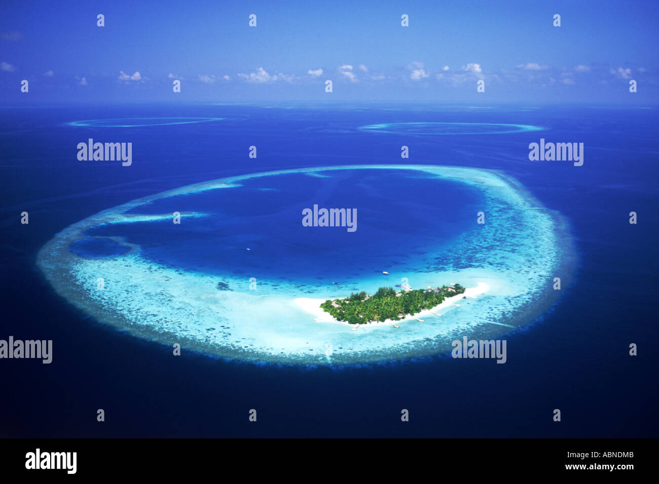 Tropical island in North East Ari Atoll with encircling reef in the Maldives surrounded by aqua blue waters of the Indian Ocean Stock Photo