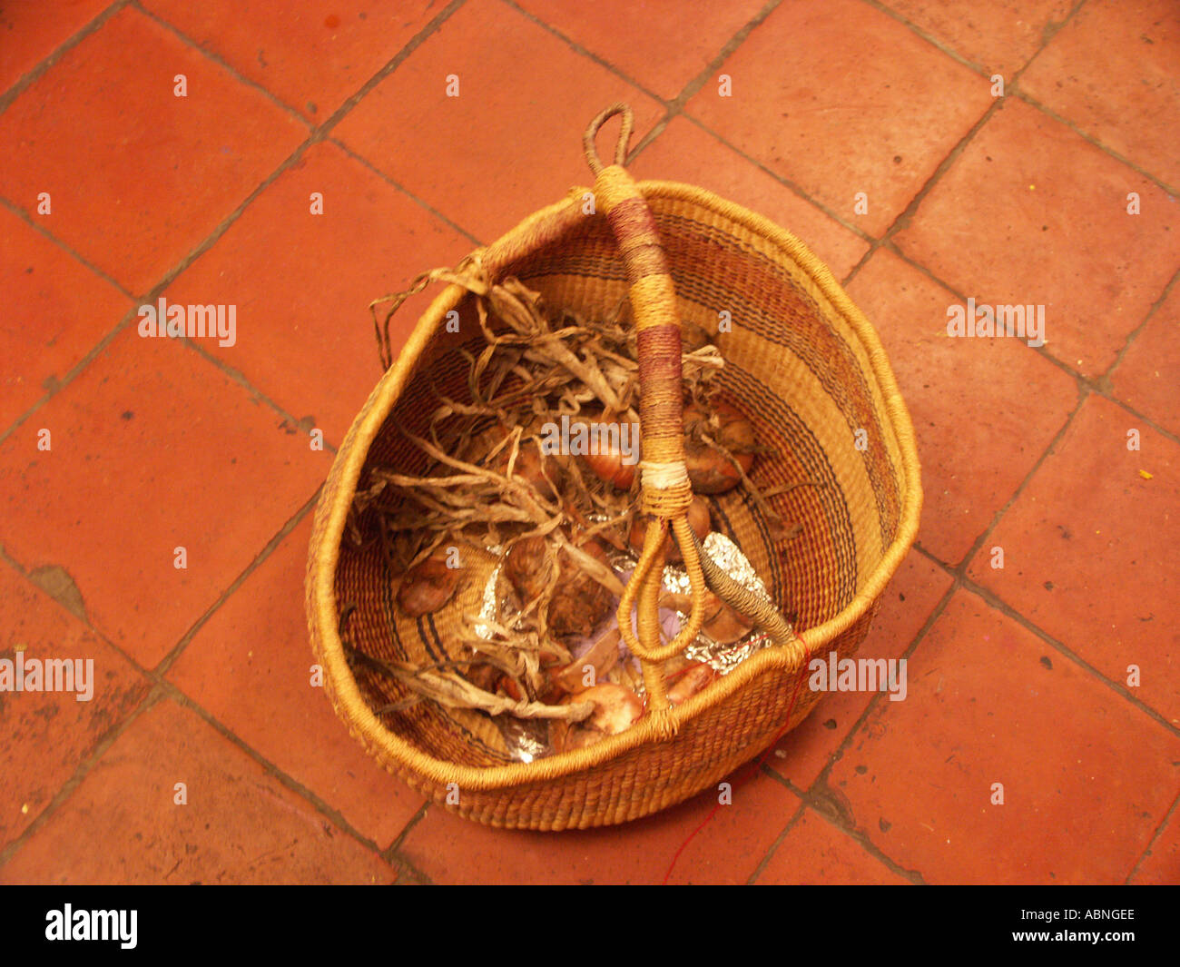 A woven basket sits on the red stoned floor of a English country