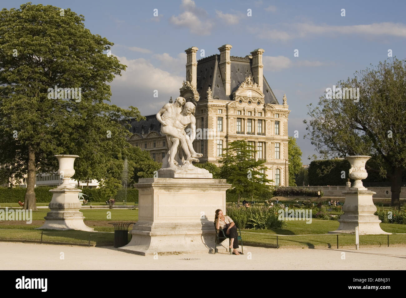 Woman With Bare Feet Sits Near Statue At Jardin Des Tuileries
