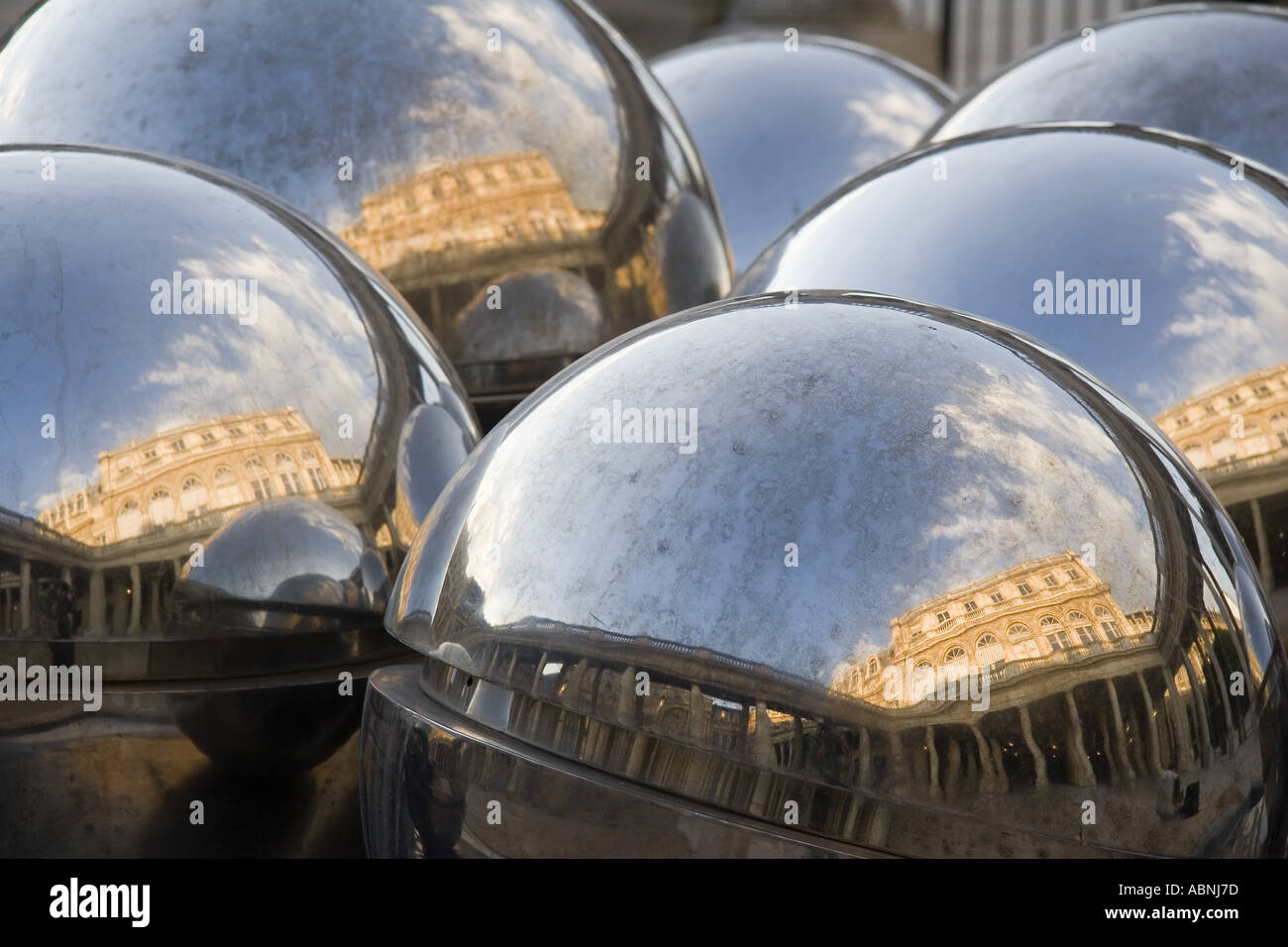 Shiny chrome silver spheres reflect the facade of the Palais Royal Paris France Stock Photo