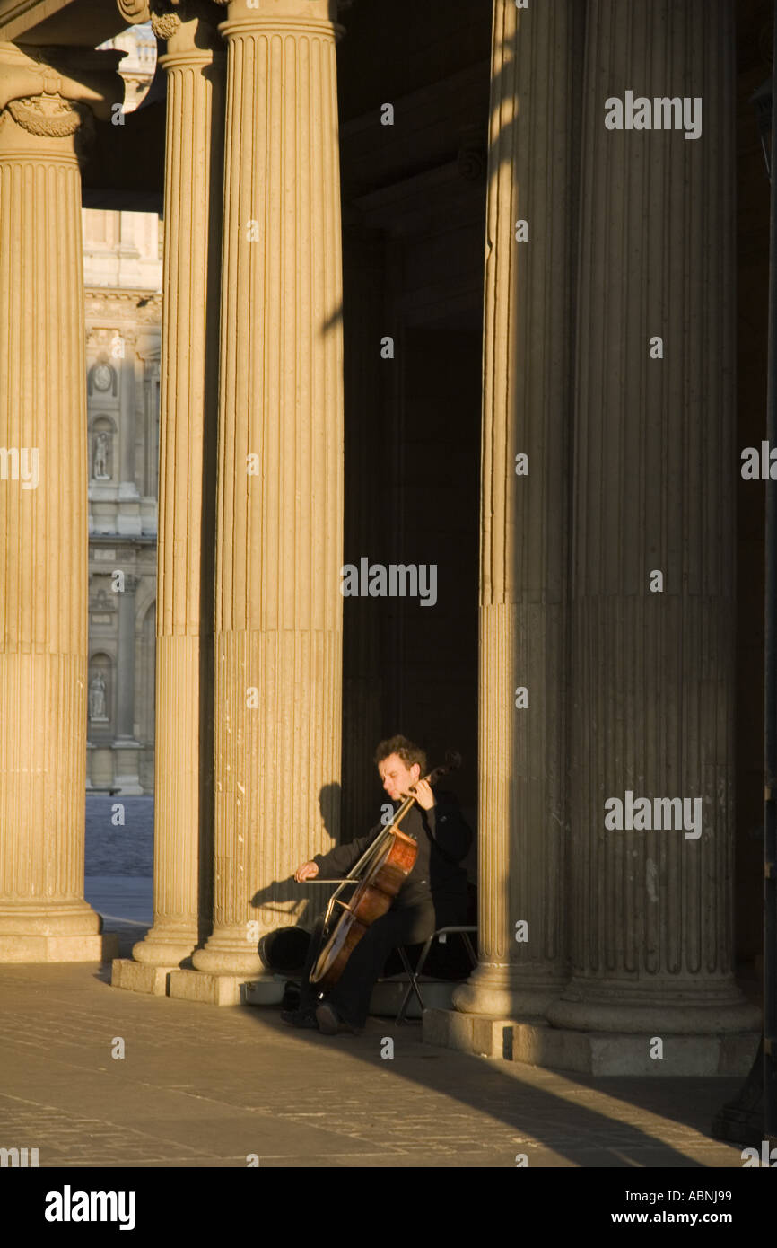 Man playing violincello near the Pyramid at Musee du Louvre Paris France Stock Photo