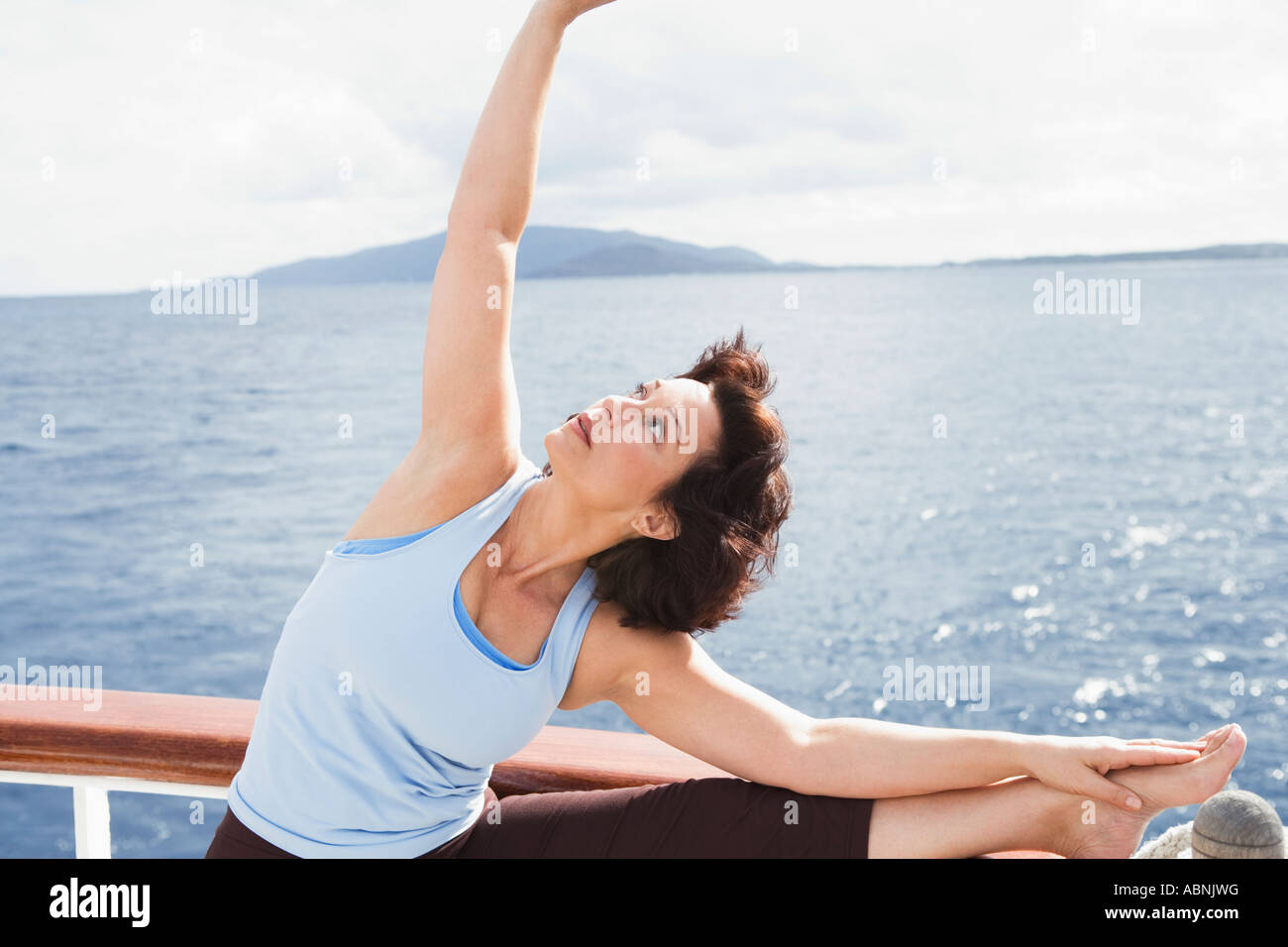 Woman stretching on ship’s deck Stock Photo