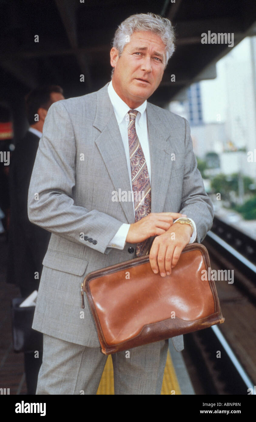 Male executive checking wrist watch while waiting for train Stock Photo
