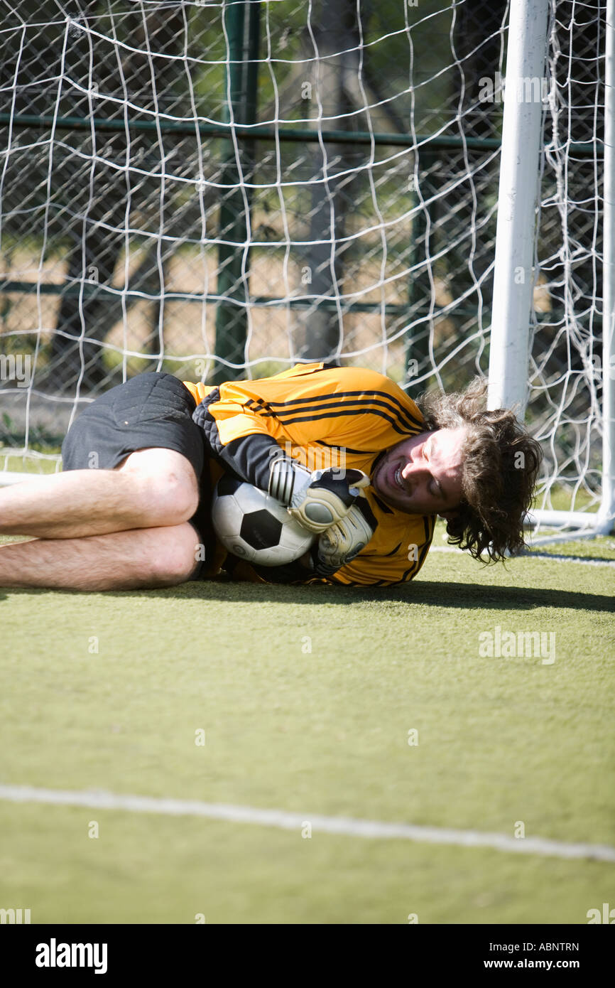 Male soccer goalie clutching the ball Stock Photo Alamy