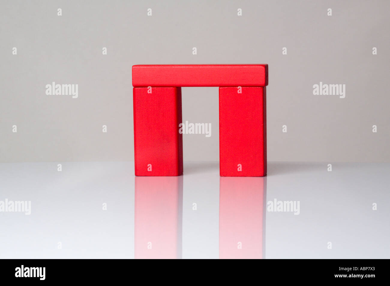 3 red wooden building blocks with a white background. 2 standing ...
