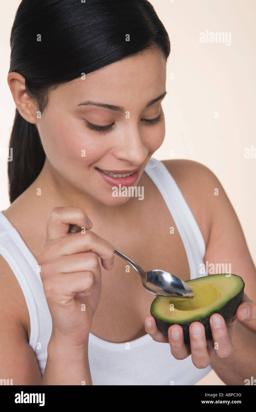 Woman eating avocado Stock Photo