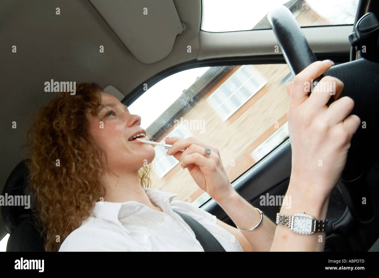 Driving, whilst, on, putting, on, make, up, cosmetics, car, driver, drive, female, woman, distracted, distraction, talk, talking Stock Photo