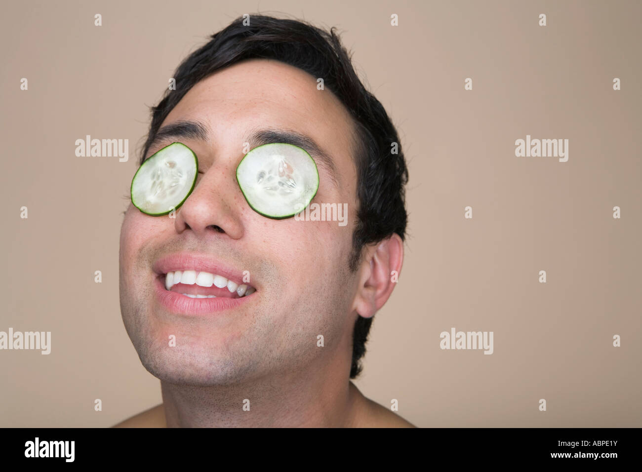 Man wearing cucumbers over eyelids Stock Photo Alamy