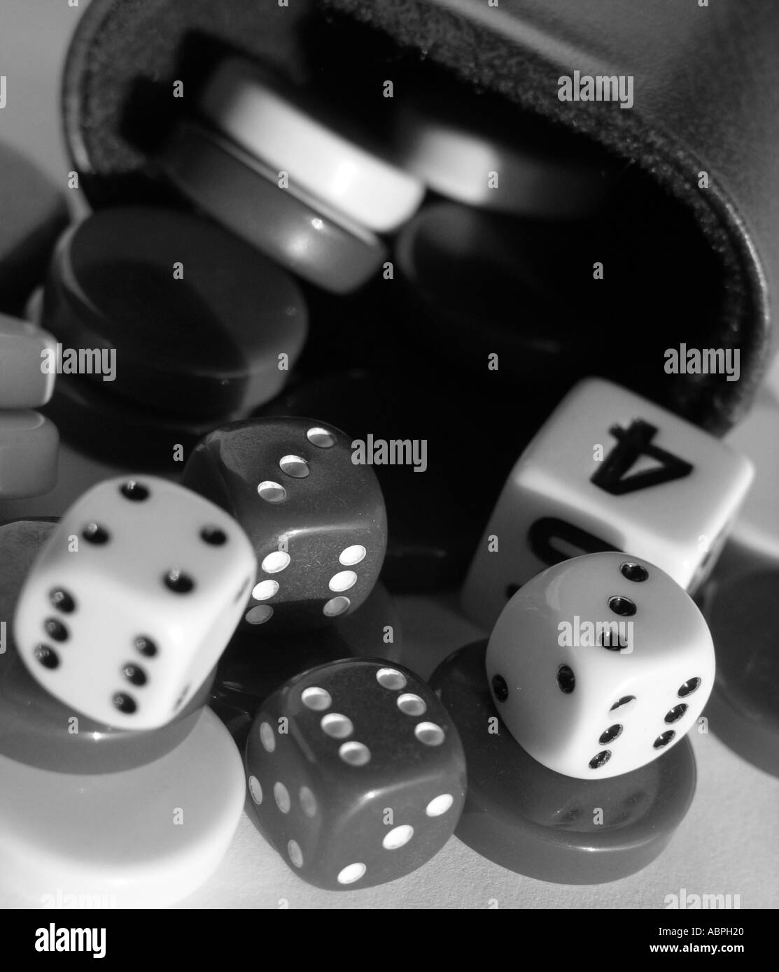 Dice, shaker and draught game pieces Stock Photo