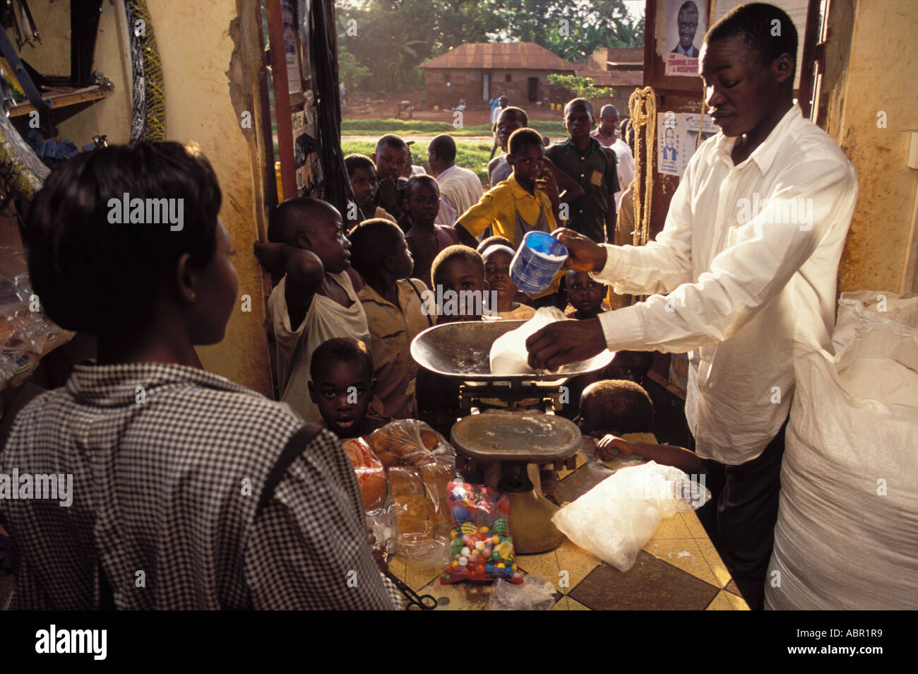 Ugandan children queuing for milk powder at village shop Stock Photo