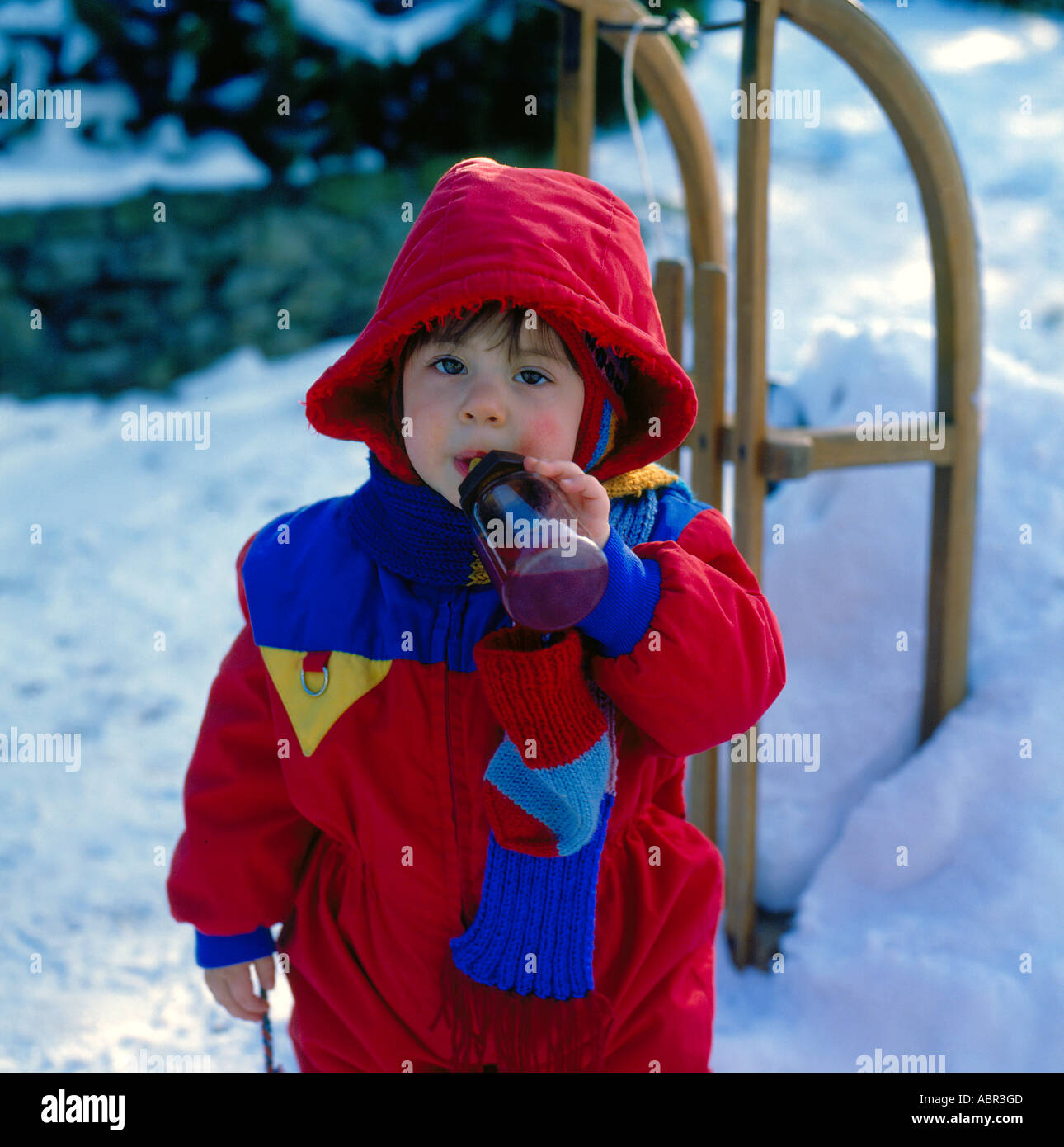 little girl outside in ski dress with drinking bottle.  Photo by Willy Matheisl Stock Photo