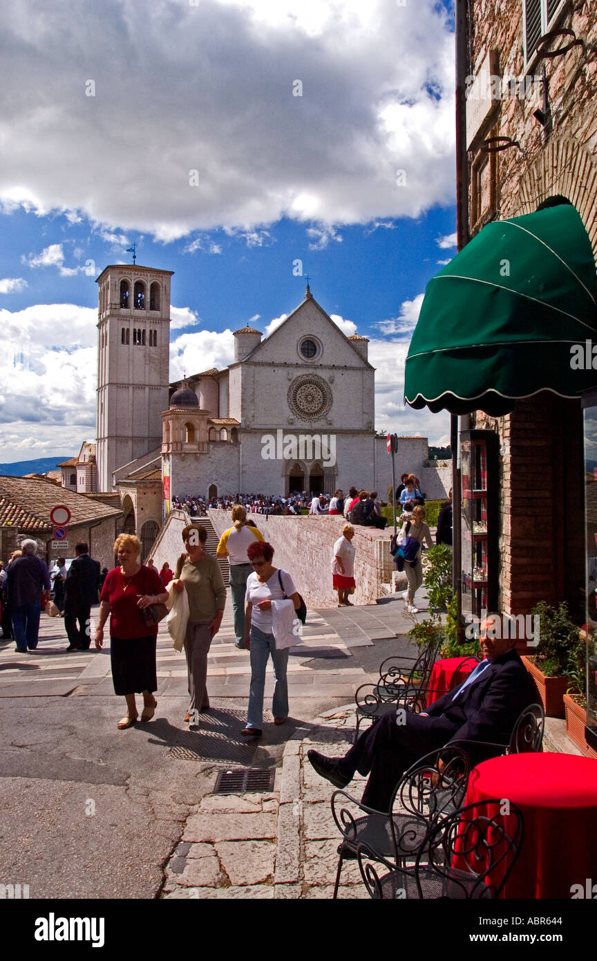 Tourists strolling past a restaurant near the Basilica di San Francesco in Assisi Italy Stock Photo